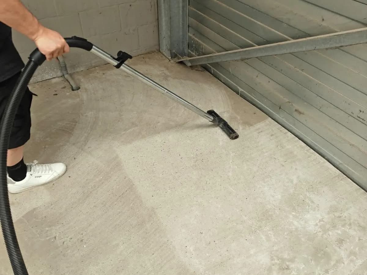 Vloer van een garage wordt gereinigd met een industriële zuigmond
